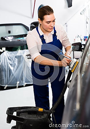 Woman mechanic sanding automobile body Stock Photo