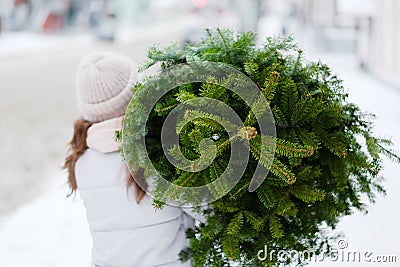Young woman carrying a christmas tree Stock Photo