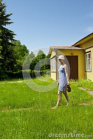 Young woman carrying jug by the summer house Stock Photo