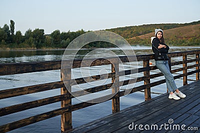 Young woman in casual warm outfit posing near lake Stock Photo