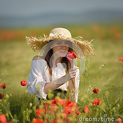 Young woman on cereal field with poppies in summer Stock Photo