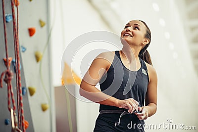 Young woman with chalked hands posing at indoor climbing gym wall Stock Photo