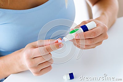 Young woman changing pencil needle to get tested for glucose on white background. Stock Photo