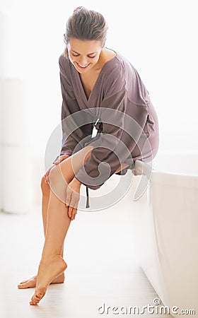 Young woman checking leg skin softness in bathroom Stock Photo