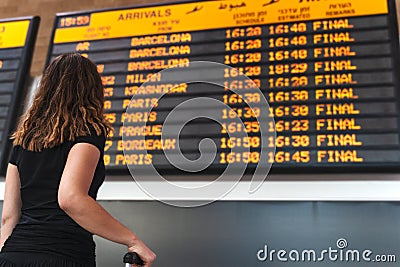 Young woman checking the timetable at the airport Stock Photo