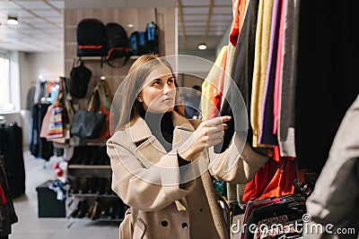 Young woman choosing clothes in clothes store Stock Photo