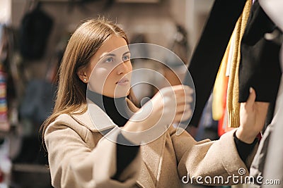 Young woman choosing clothes in clothes store Stock Photo