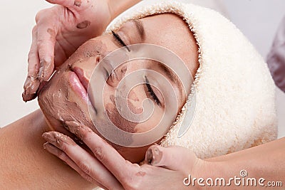 Young woman with clay facial mask. Stock Photo