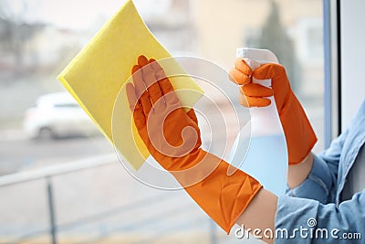 Young woman cleaning window glass at home Stock Photo