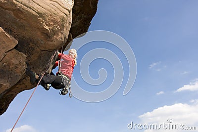 Young woman climbing a rock Stock Photo