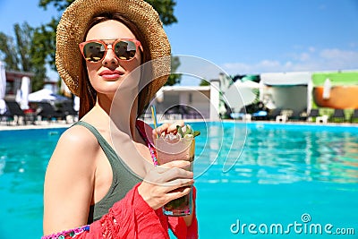 Young woman with cocktail relaxing at swimming on sunny day Stock Photo