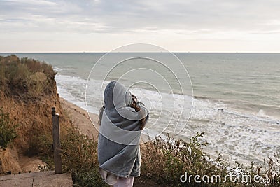 Young woman on cold autumn seashore posing at camera Stock Photo
