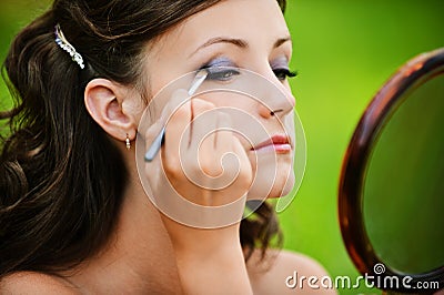 Young woman colouring her eyelids Stock Photo