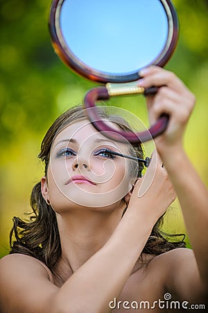 Young woman colouring her eyelids Stock Photo