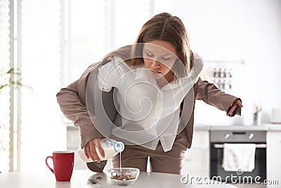 Young woman cooking breakfast in hurry at home Stock Photo