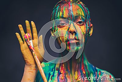 Young woman covered with a colourful paint Stock Photo