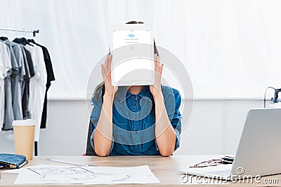 young woman covering face by digital tablet with skype application Editorial Stock Photo