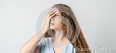 Young woman covers face, rolled eyes, feels fatigue, needs good rest. Weariness and people Stock Photo