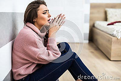 Young woman after cry sitting on whte floor at home in depression. A woman sitting alone and depressed. The depression woman sit o Stock Photo