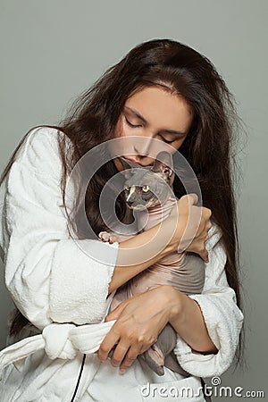 Young woman cuddling sphinx cat Stock Photo