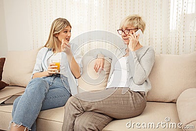 Young woman is curious and anticipating good news from her mother who is talking on the phone Stock Photo