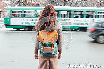Young woman curly red head girl traveller with backpack in front of tram at the city street Editorial Stock Photo