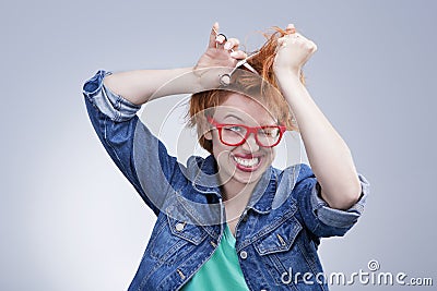 Young woman cuts her hair with scissors Hairdressing Stock Photo
