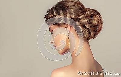 Young woman is demonstrating deep blonde hair gathered in elegant hairstyle. Stock Photo