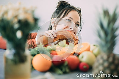 Young woman on a diet succumbed to temptation and passionately bites a white crispy long loaf Stock Photo