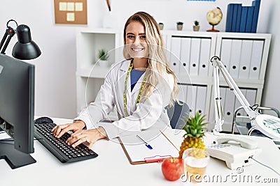 Young woman dietician smiling confident using computer at clinic Stock Photo