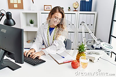 Young woman dietician smiling confident using computer at clinic Stock Photo