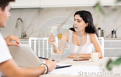 Young woman discussing deal with salesman in kitchen Stock Photo