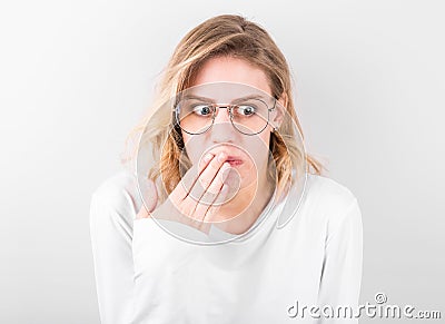 Young woman disgusted squeamishness over gray wall background Stock Photo