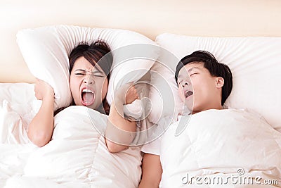 Young woman disturbed by the snores of her husband Stock Photo