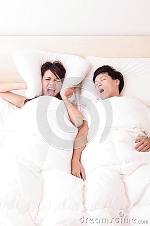 Young woman disturbed by the snores of her husband Stock Photo