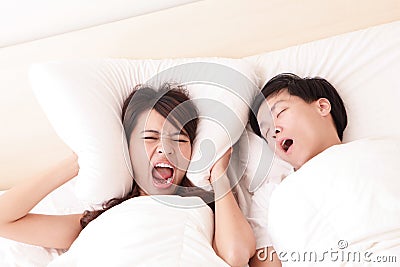 Young woman disturbed by the snores of her husband Stock Photo