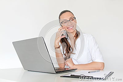 A young woman doctor With a laptop in her office talking on the phone Stock Photo