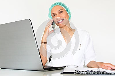 A young woman doctor With a laptop in her office talking on the phone Stock Photo