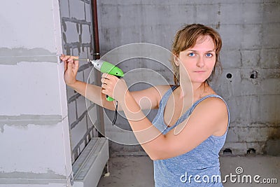 A young woman is doing repairs in her house. Repair work in the apartment yourself Stock Photo