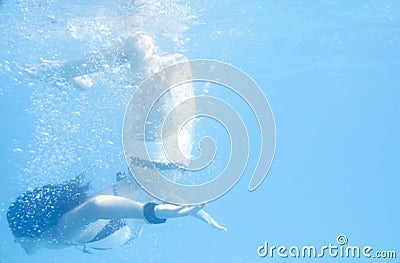 Young woman doing a somersault underwater. Stock Photo