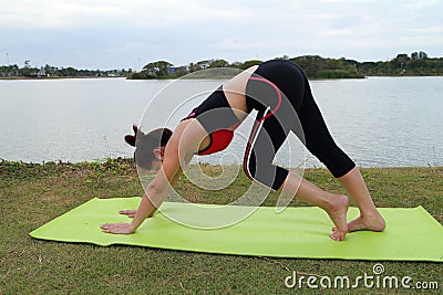 Young woman doing yoga exercise in park Stock Photo