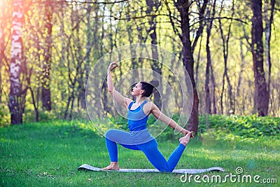 Young woman doing yoga exercises in the summer city park. Health lifestyle concept. Stock Photo