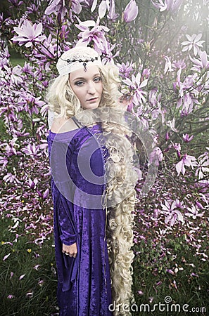 Young woman dressed as Rapunzel in purple gown Stock Photo