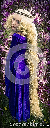 Young woman dressed like Rapunzel with long blond hair. Stock Photo