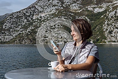 Young woman drinking coffee and using smarphone in the morning a Stock Photo