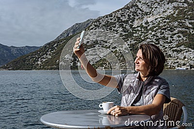 Young woman drinking coffee and using smarphone in the morning a Stock Photo