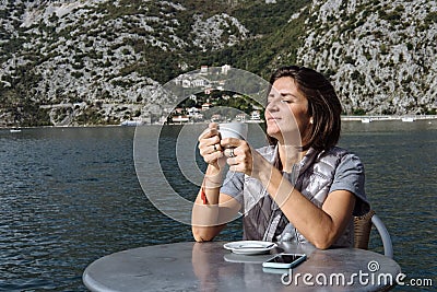 Young woman drinking coffee and using smarphone in the morning a Stock Photo