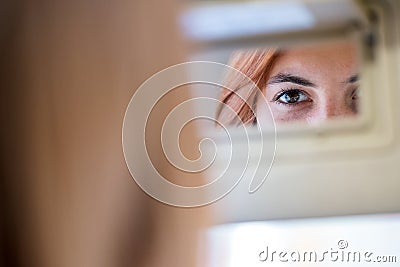 Young woman driver checking rear view mirror looking backwards while driving a car Stock Photo