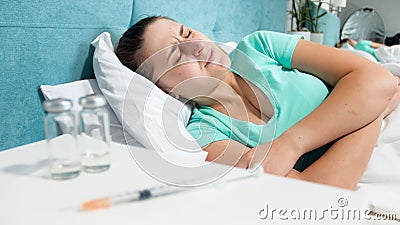 Portrait of young woman with drug addiction lying in bed and suffering from pain Stock Photo