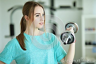Young woman with dumbbell in gym Stock Photo